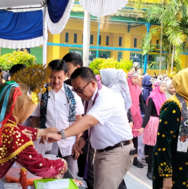 Photo 1: Students in classroom engaged in learning, bright and lively environment with books and laptops